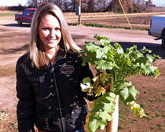 Volunteer holding a farm vegetable