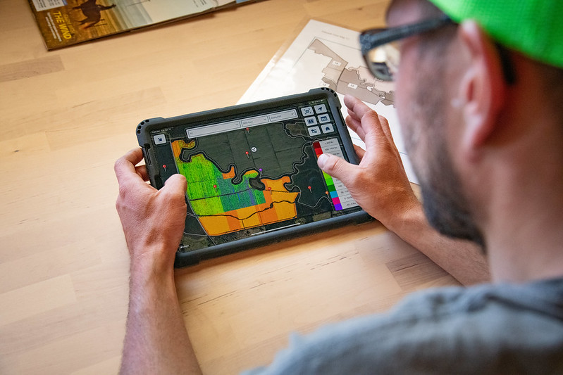 An image of a man using geospatial software on a pad.
