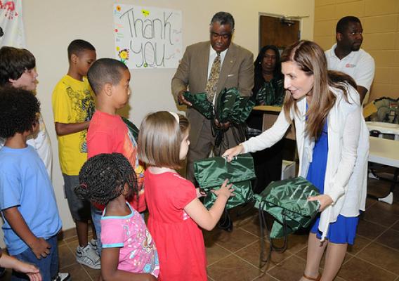 FNS Deputy Administrator Lisa Pino (right) and Southeast Regional Administrator Don Arnette (left) hand out meals and backpacks to kids at a Salvation Army summer feeding site in Marietta, GA during National Summer Food Service Program Week. 