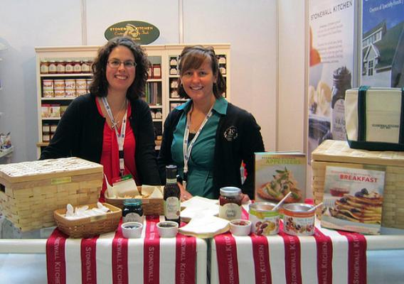 Carol Deeney (left), Stonewall Kitchen’s international marketing director, and Stephanie Miller, Stonewall’s social media and marketing coordinator, man a booth at the 2012 Gulfood Trade Show. The Foreign Agricultural Service’s Market Access Program helps the specialty foods company participate in trade shows, which helps increase its international exposure and exports. (Courtesy Photo)