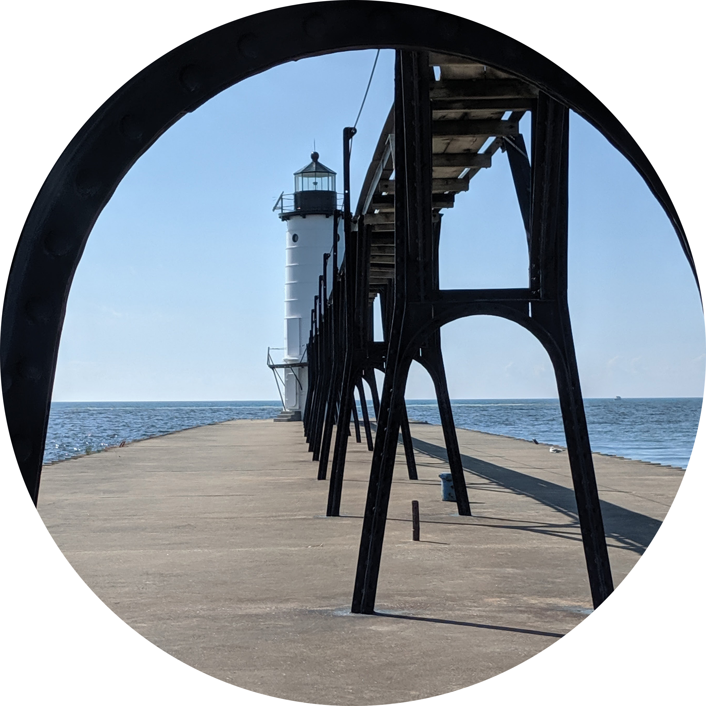 Photo of a lighthouse Framed by a pier support in the foreground