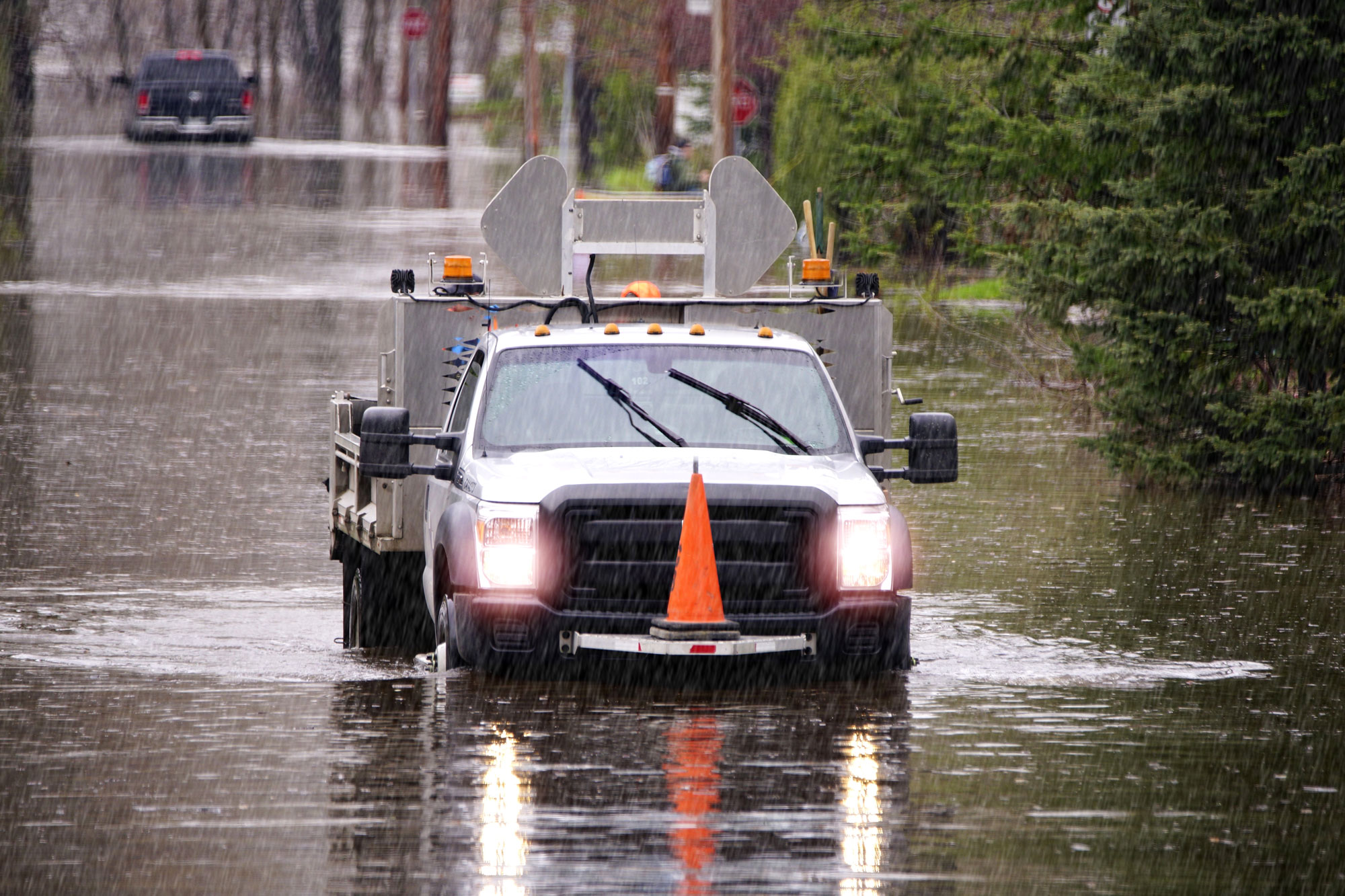 A truck driving through a flooded street