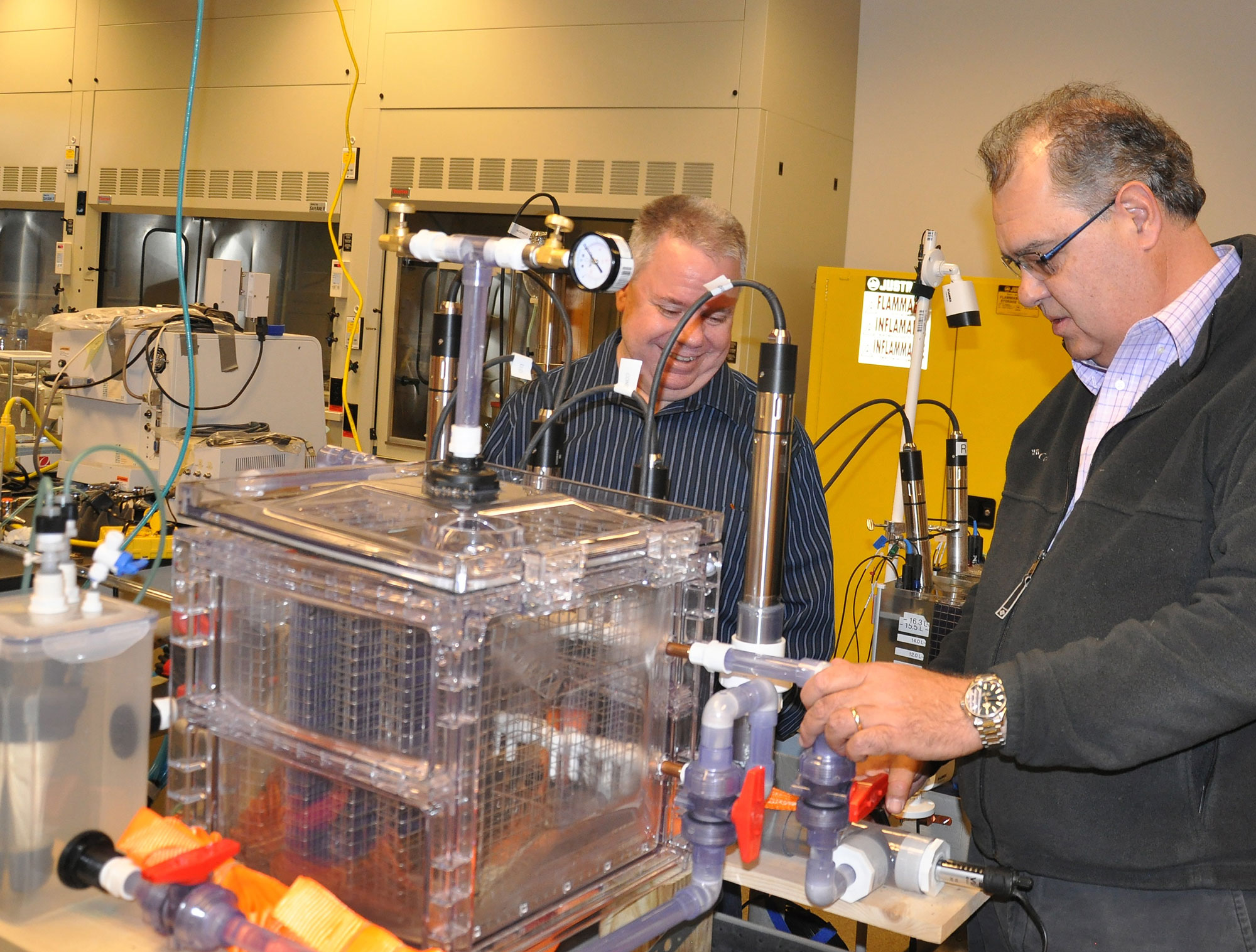 In a lab, CEO of Pancopia Inc, Research partner Bill Cumbie, CEO of Pancopia, Inc., (left) and Matias Vanotti, soil scientist from the Agricultural Research Service, inspect a prototype space bioreactor using anammox