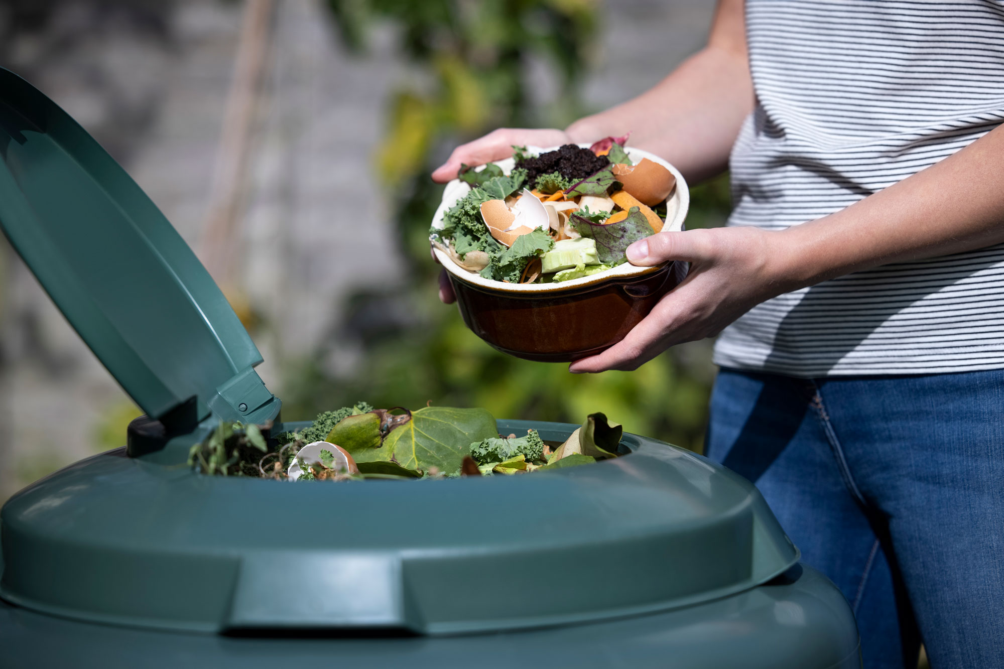 A person throwing out food into the trash