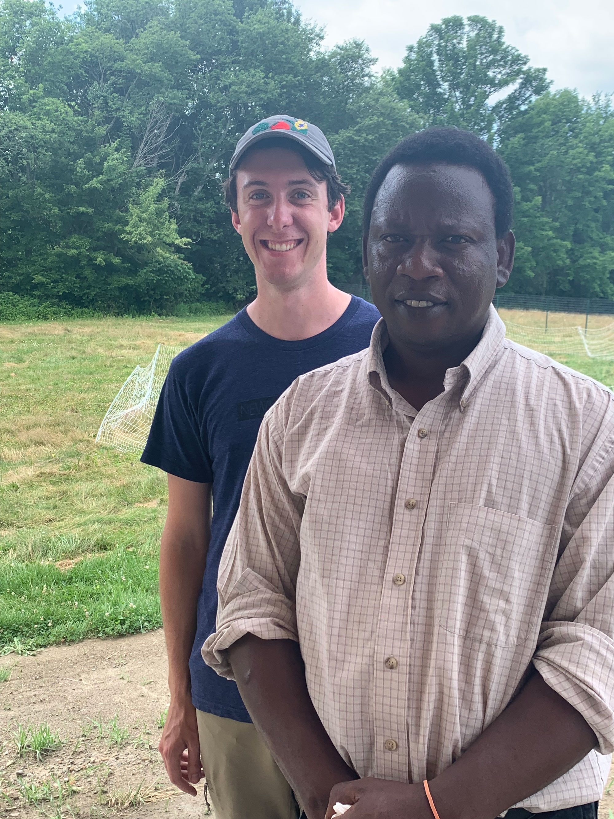 Somali Bantu Community Association of Maine Executive Director Muhidin Libah stands with SBCA Intern Holden Turner on farmland