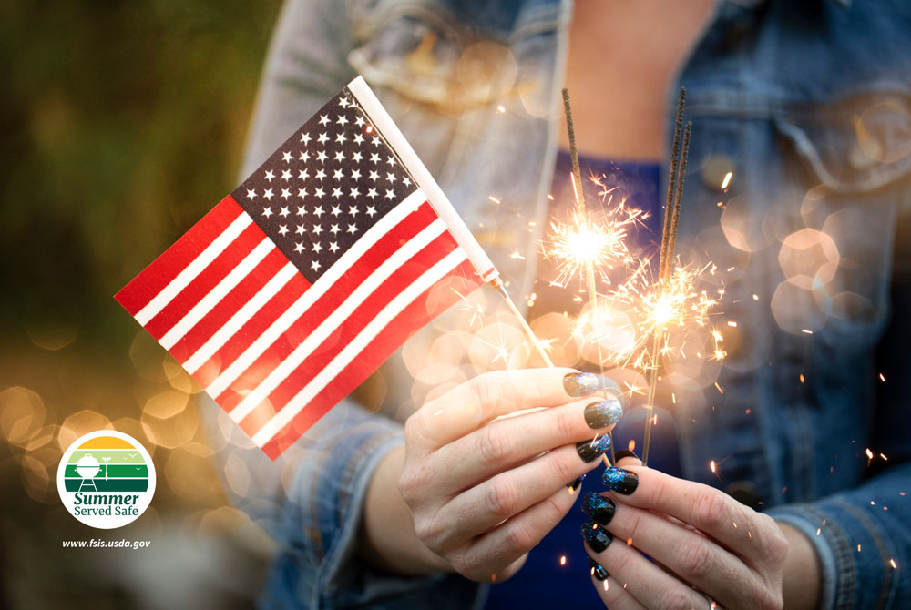 A person holding the U.S. flag and fireworks with the Summer Served Safe FSIS logo