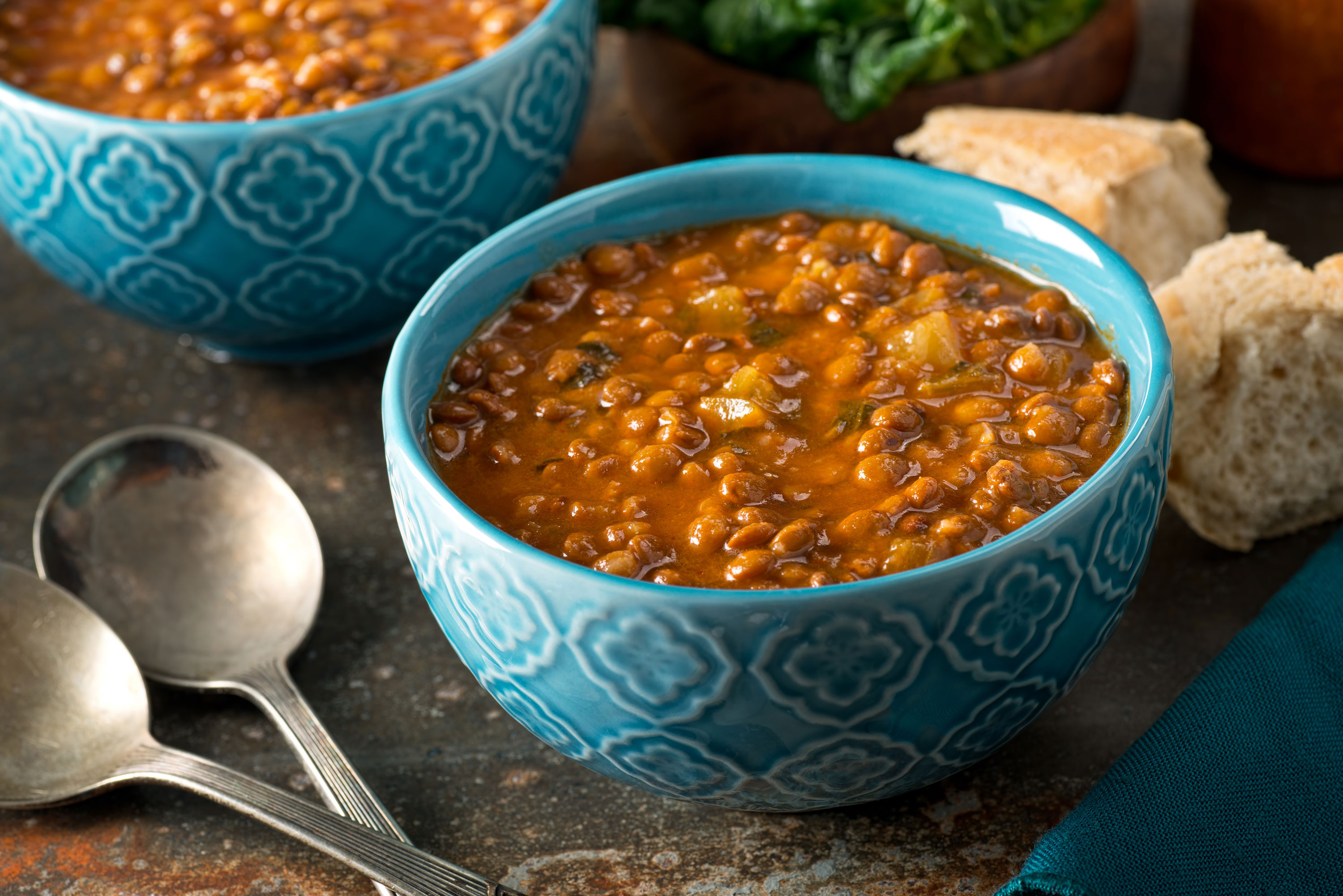 A blue bowl filled with lentil soup on a table