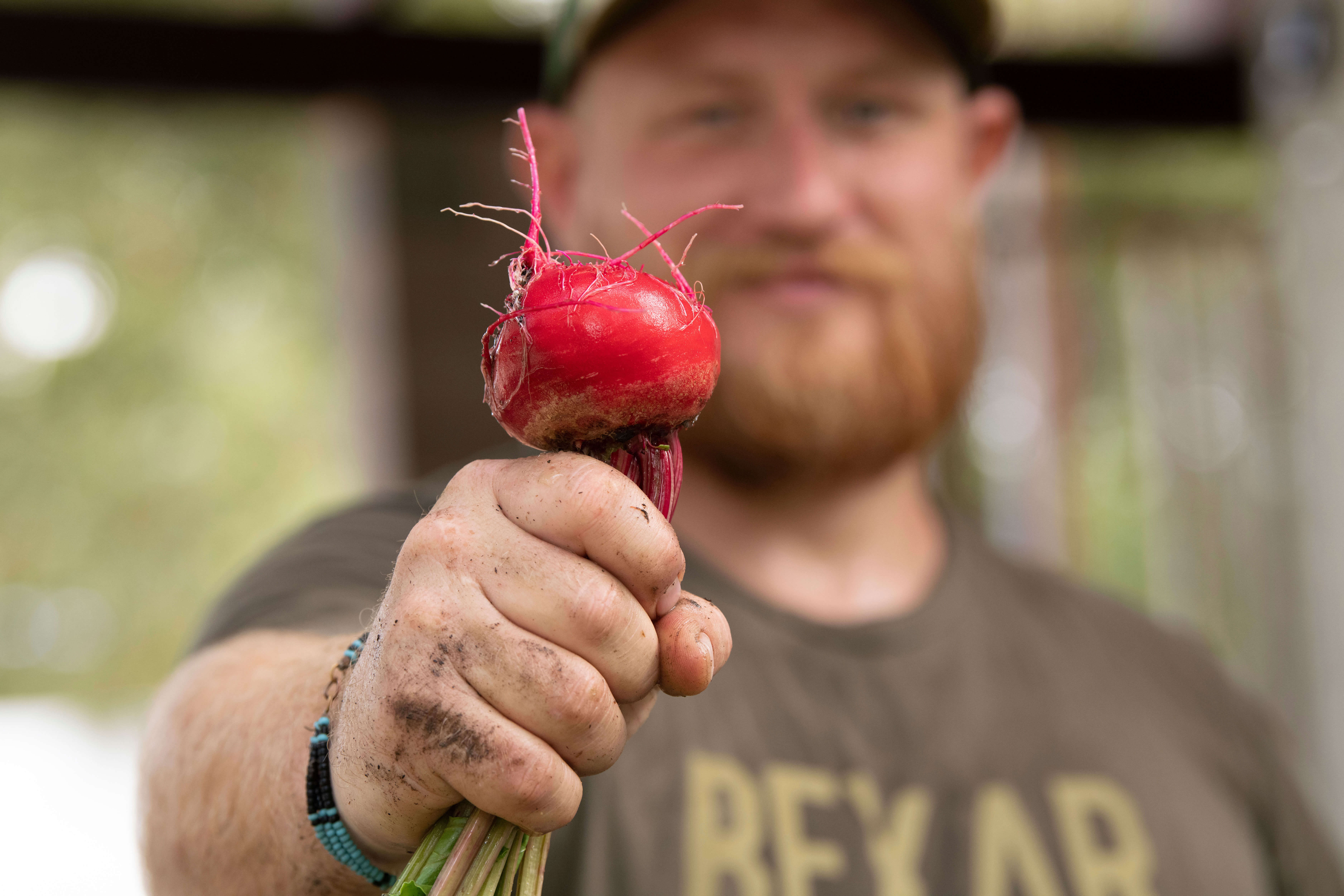 Farmer Cody Scott presents a freshly-harvested red beet grown on Green Bexar Farm, in Saint Hedwig, Texas, near San Antonio