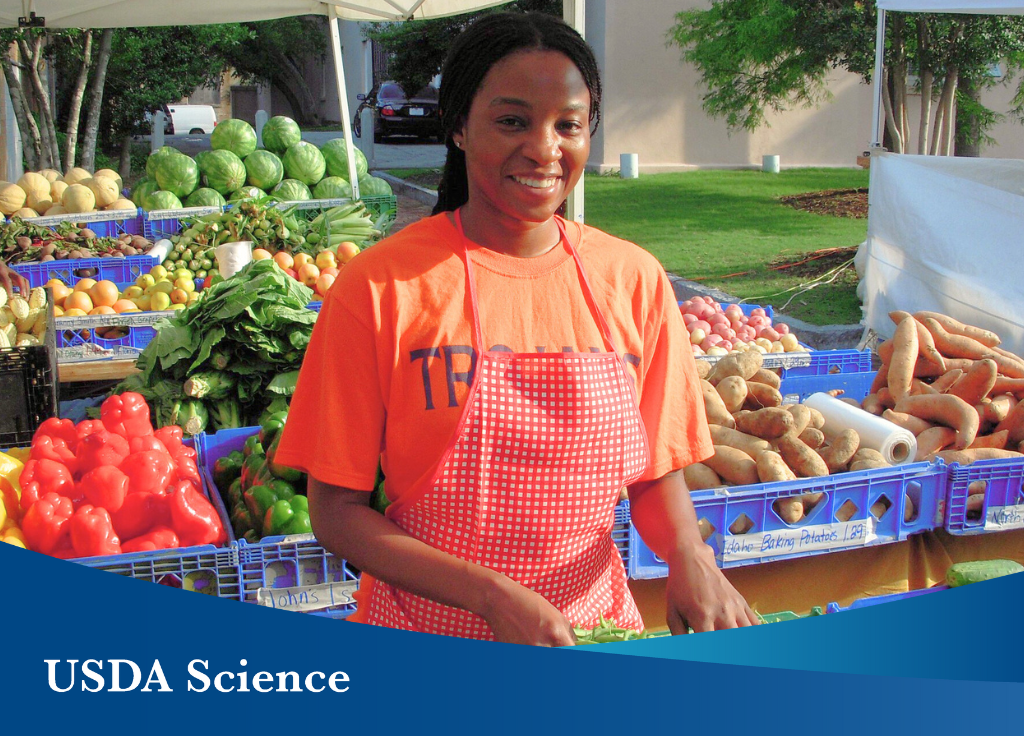 A woman in front of produce at a farmer's market