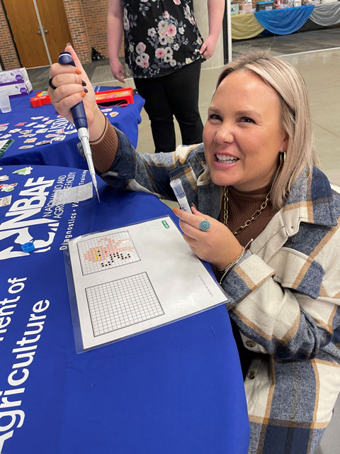 Krystle Hensley, NBAF biosafety level-4 lab manager, shows off pipetting skills at Rock Creek STEAM Night