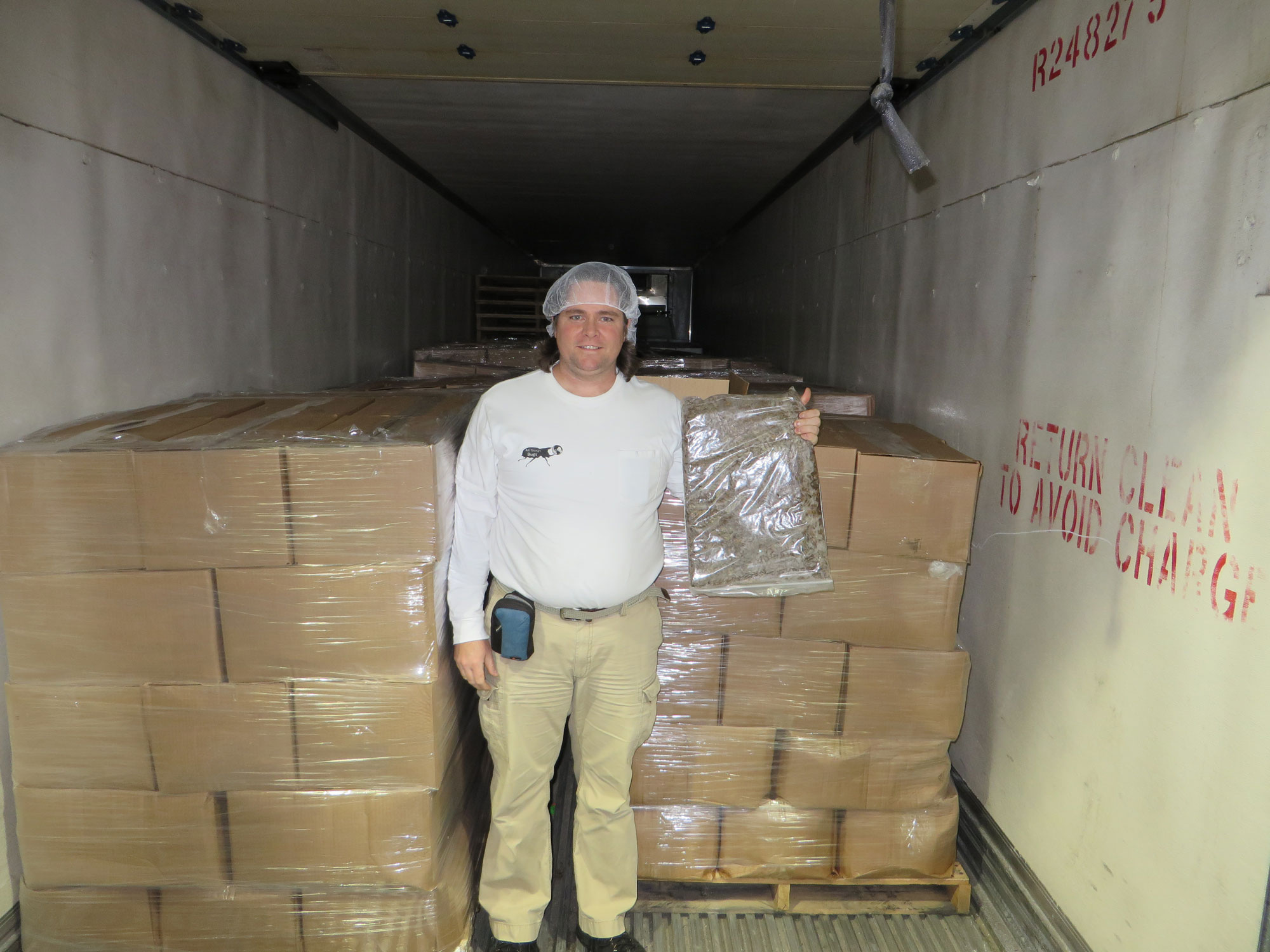 Dr. Aaron Dossey holding the product beside boxes