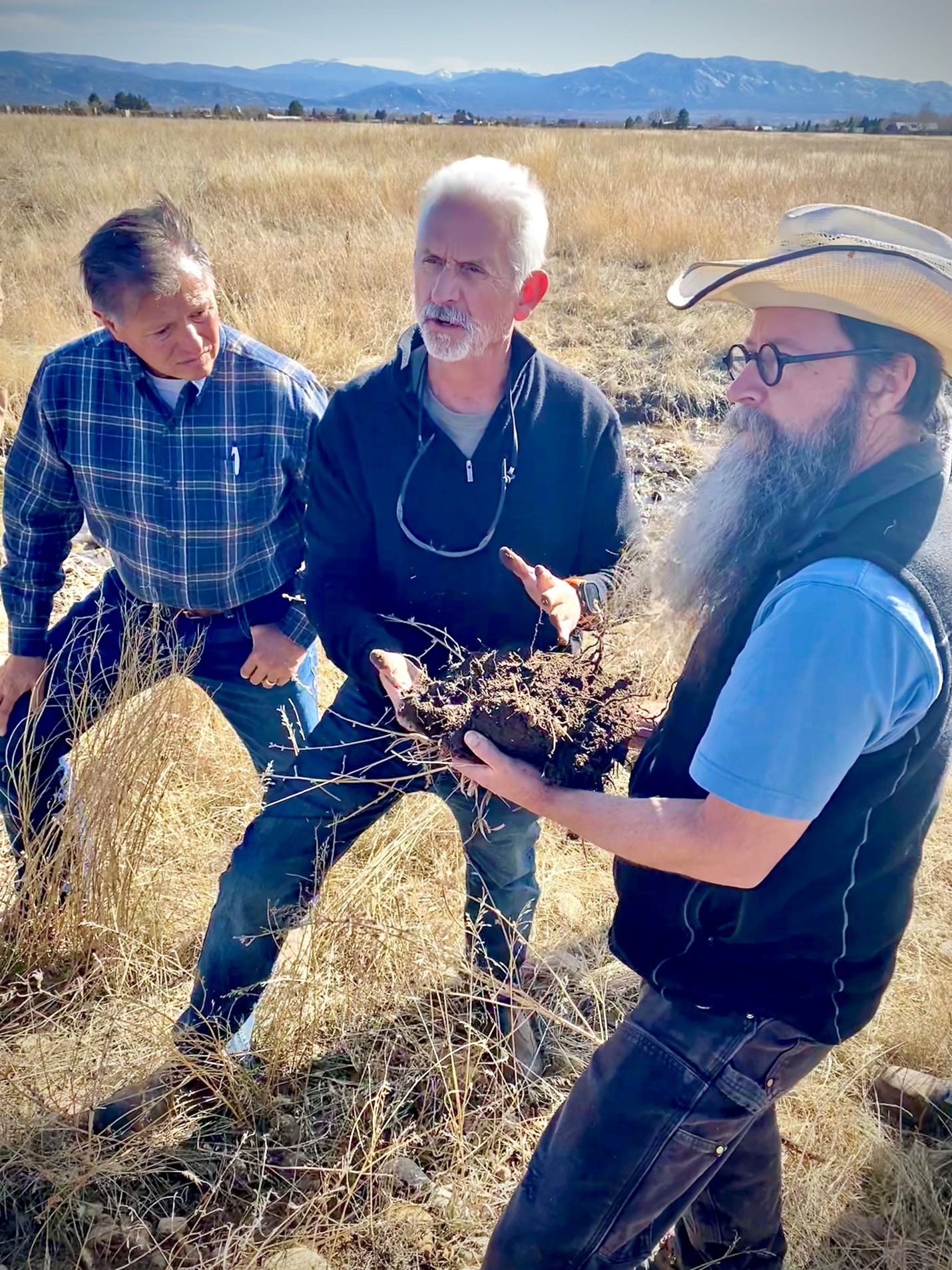 Three men talking in a field