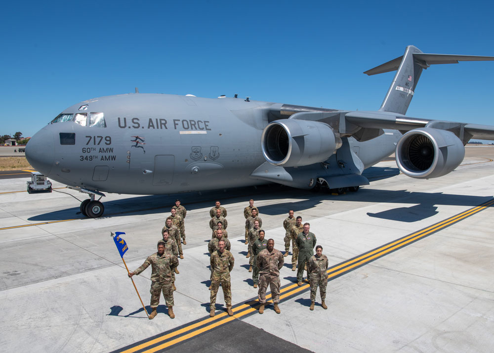 A photo of a group of military members on a tarmac with an airplane in the background