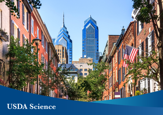 The Philadelphia skyscape with a blue banner in the forefront with text that reads“USDA Science.”