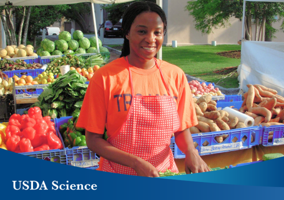 A woman in front of produce at a farmer's market