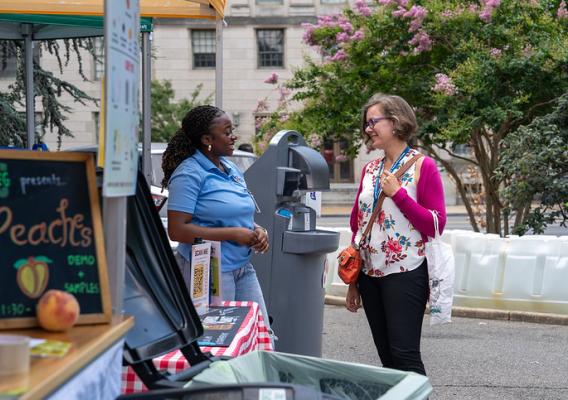 two women engage at an outdoor market