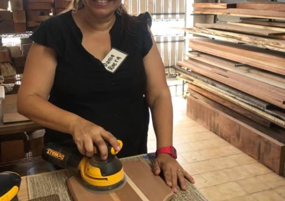 Woman making a cutting board with wood salvaged from Hurricane Maria