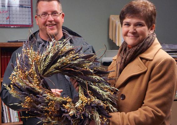 Ralph Cramer shows Deputy Harden some of the wreaths created with dried flowers from Cramer’s Posie Patch.