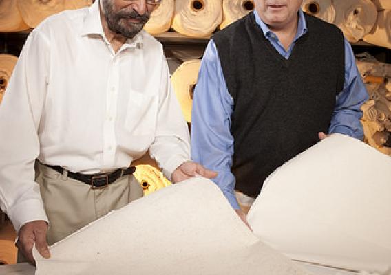 ARS cotton technologist Paul Sawhney (left) and research leader Brian Condon examine needled-punched nonwoven products made with classical raw cotton and precleaned raw cotton, respectively.