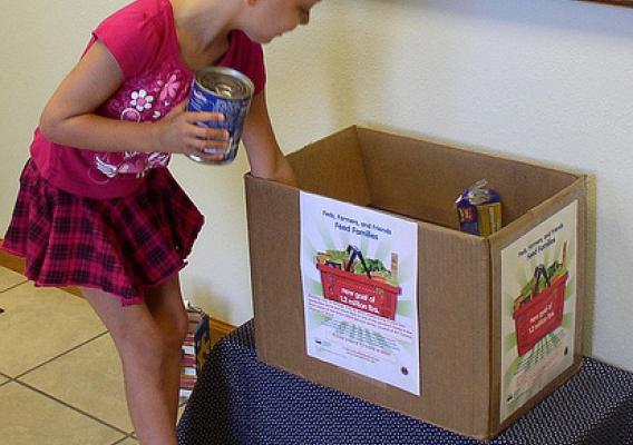 Mackayla Wallin, age five, makes her contribution to feed the hungry in Grant, Neb. at the recent “Feds, Farmers, and Friends Feed Families” food drive.