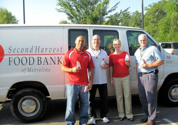 (from left to right): A representative from Second Harvest Food Bank displays jars of honey donations with NSL’s Charles Lay, Quality Manager; Lea Fleming, Management Analyst; and Jonathan Barber, Chemist.
