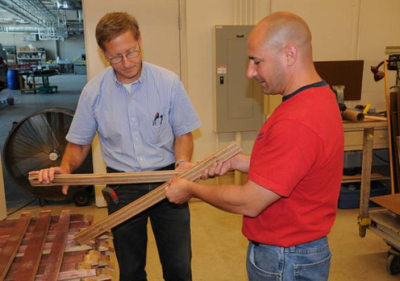 Forest Products Lab engineer John Hunt (left) and Jubliee Flooring owner Joe Triglia inspect flooring milled from discarded wine barrel staves.