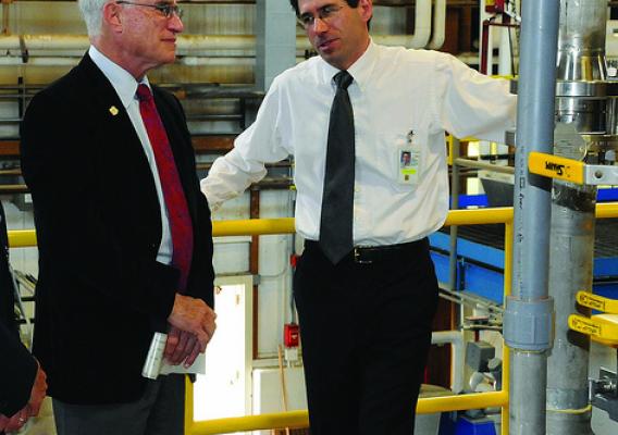 Forest Product Lab chemical engineer Rick Reiner (right) shows Under Secretary Sherman the new nanocellulose pilot plant.